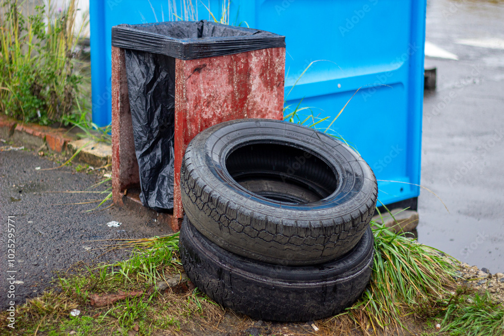Obraz premium Discarded car tires. Pollution of the street with industrial waste. Environmental disaster