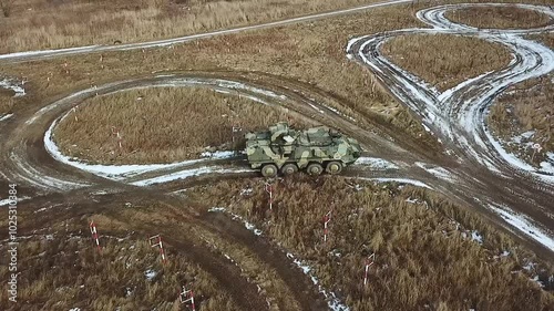 AERIAL VIEW: Armored Ukrainian personnel carrier training ground performs exercises to pass obstacles. Military equipment training ground in Ukraine. Training track at a military training ground