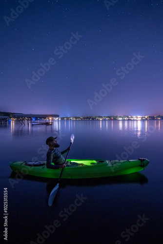 Man Kayaking At Night Under The Stars