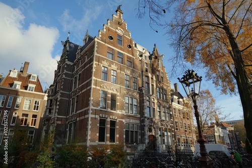 Traditional dutch architecture building standing tall on an amsterdam canal with a street lamp in the foreground