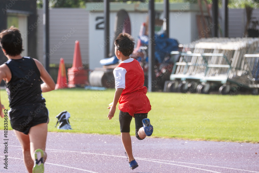 Obraz premium 陸上大会でリレーを走る小学生の男の子
