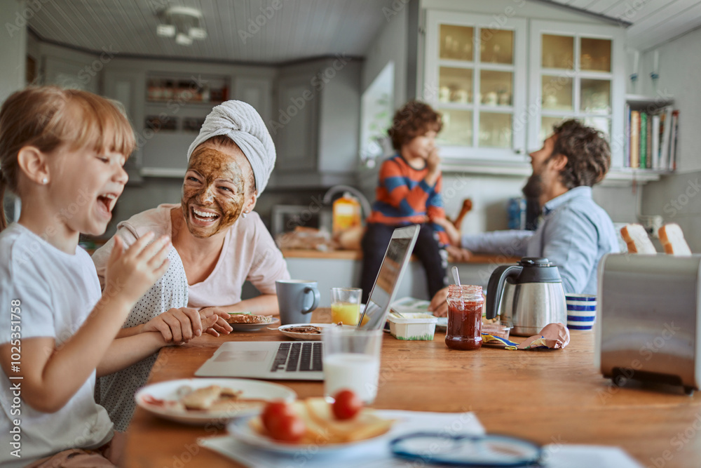 Family laughing during breakfast in kitchen Family laughing during breakfast in kitchen