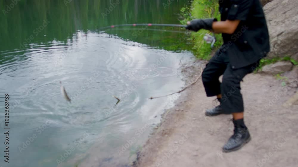 Man reeling in live fish from lake and celebrating Man reeling in live fish from lake and celebrating
