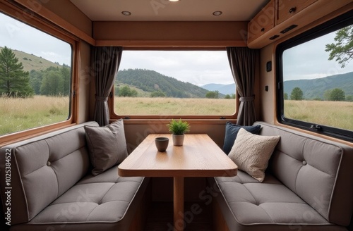 Cozy interior of a camper van with a wooden table and scenic mountain view during the day