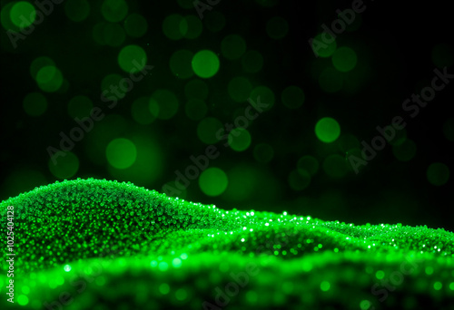 Close-up of green speckled substance on black background with blurred green bokeh, abstract and mysterious.