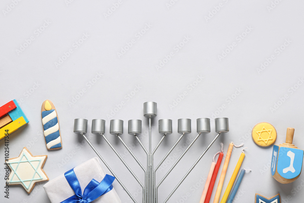 Hannukah composition with menorah, dreidel, candles and gift box on grey background Hannukah composition with menorah, dreidel, candles and gift box on grey background
