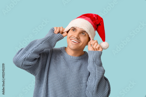 Smiling young man in santa ...