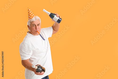 Senior man in party hat wit...