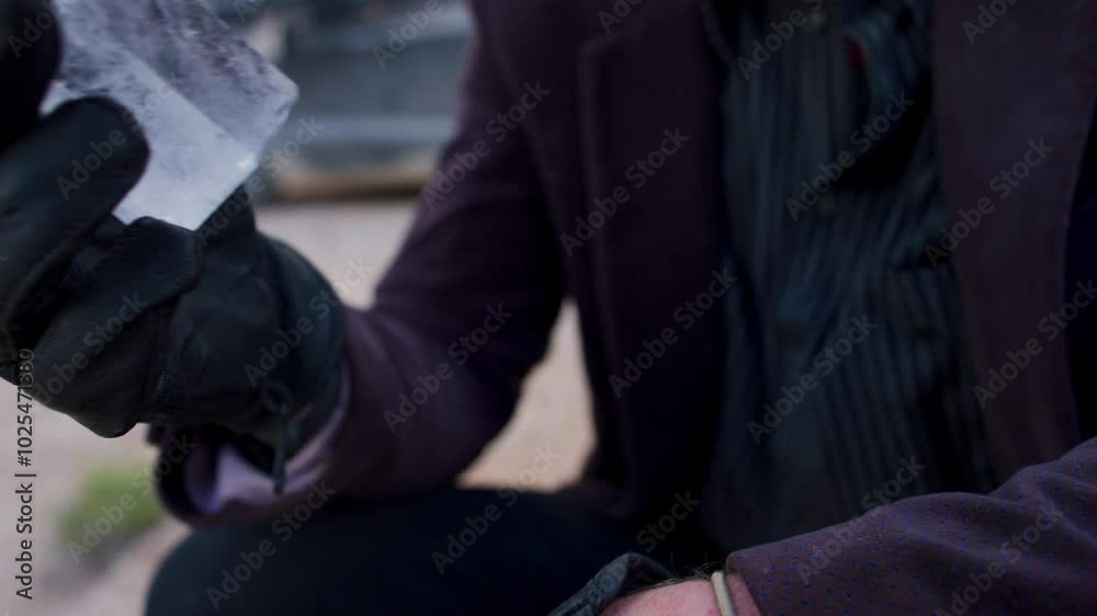 Gloved hands reaching into jacket and pulling out crystal - close up Gloved hands reaching into jacket and pulling out crystal - close up