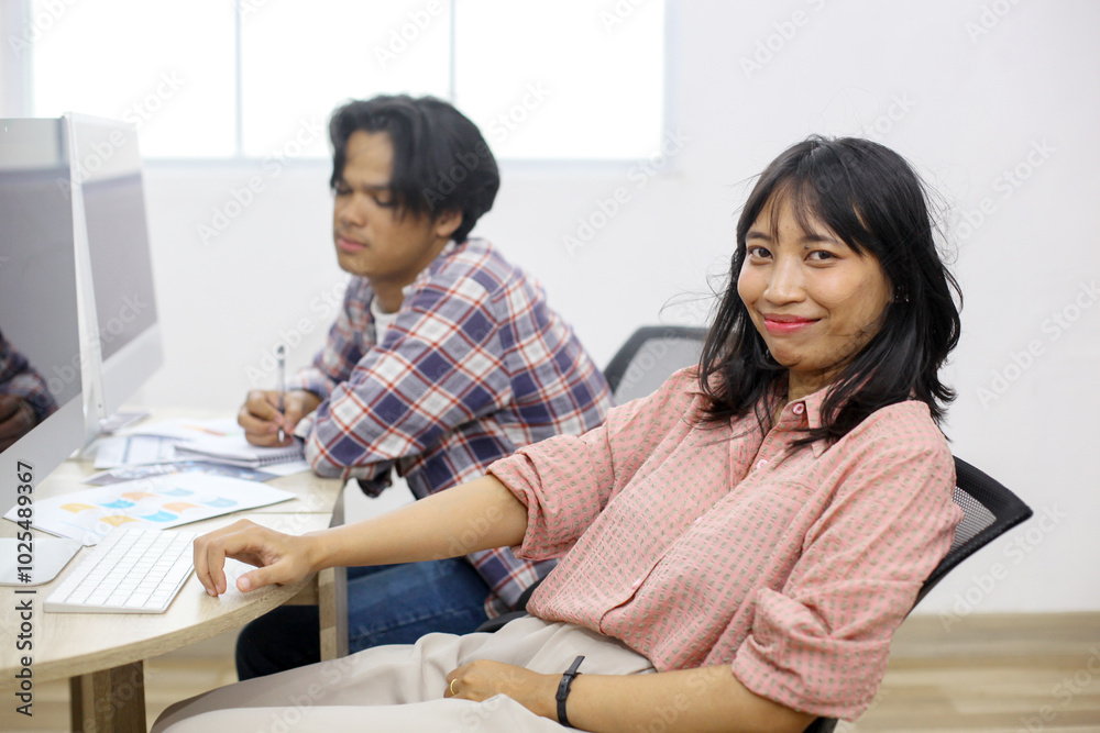 Young Asian Female And Male College Students Sitting And Learning In Computer Lab Young Asian Female And Male College Students Sitting And Learning In Computer Lab