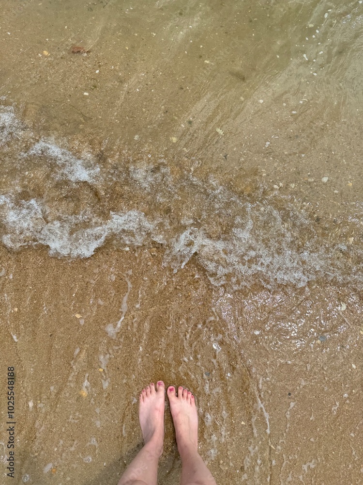Fototapeta premium feet on the beach,with sea water and sands,This photo was taken on the beach in A Coruña, Spain