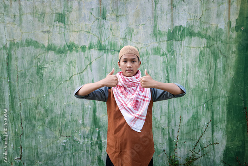 Wearing a peci and turban, a Muslim man gives a thumbs-up as a sign of agreement photo