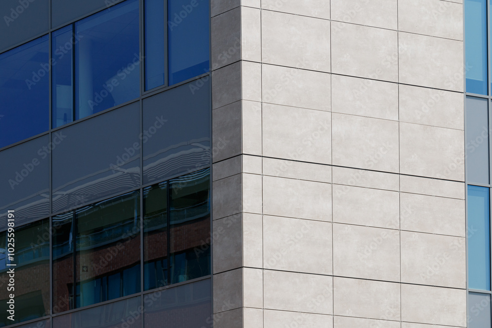 Obraz premium A modern building facade featuring a geometric pattern of blue panels with rectangular windows. 