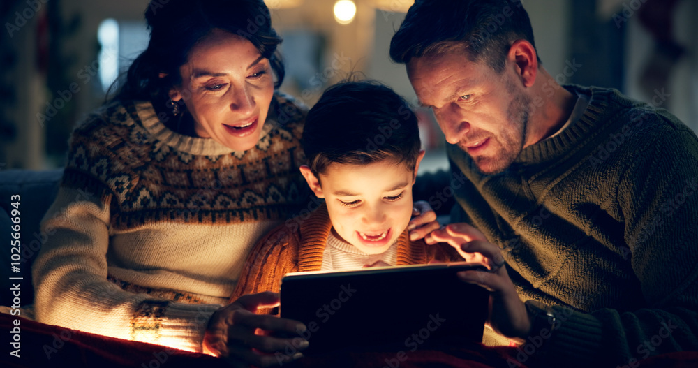 Fototapeta premium Tablet, relax and child with parents in home watching movie, film or show online for entertainment. Happy, light and kid on sofa with mother and father streaming video on digital technology at night.