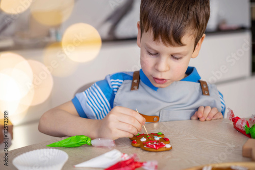 Merry Christmas and Happy Holidays. Boy cooking Christmas gingerman cookies. photo