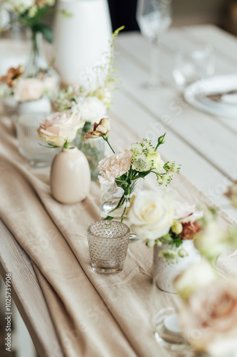 Elegant neutral coloured wedding table scape with flowers and candles