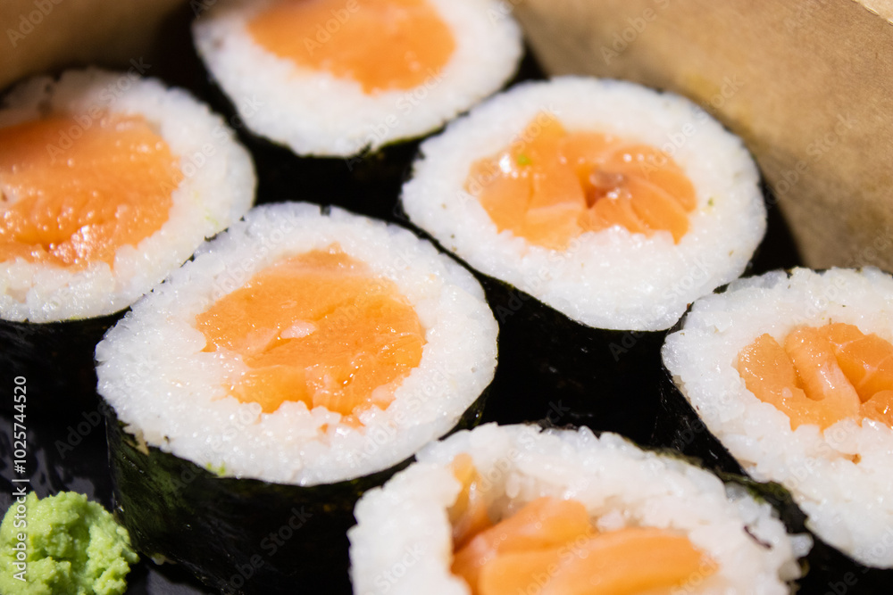 Close up of fresh sushi maki with salmon in a take away box Close up of fresh sushi maki with salmon in a take away box