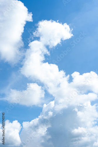 Fluffy white clouds drift across a bright blue sky, painting a beautiful picture of nature's grandeur