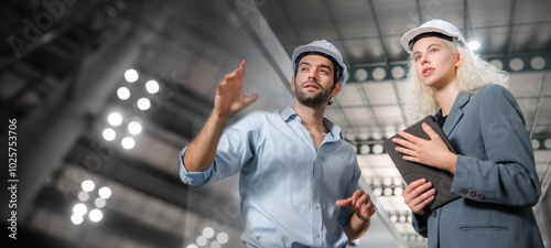 A portrait of an industrial man and woman engineer with tablet in a factory, working.
