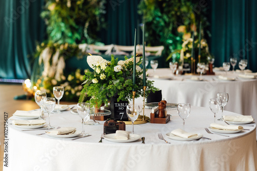 Luxurious restaurant. Luxurious interior, white tables, serving dishes and glasses for guests. Green decor photo