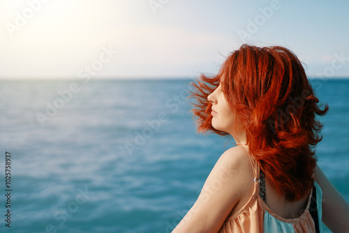 A young woman looks back on the beach against the radiant blue sea essence of a sunlit day.