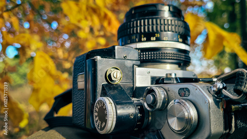 film vintage camera lies on the background of autumn nature