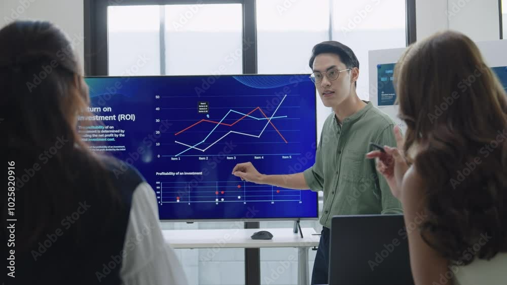 asian leader presenting a financial data and strategies in a modern office with charts and graphs displayed on a large screen