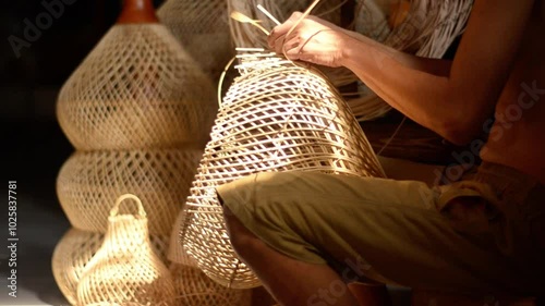 A craftsman is weaving handmade rattan lamps in an industrial house