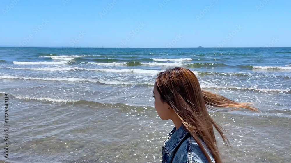 青い空と青い海のビーチを歩く髪の長い女性 青い空と青い海のビーチを歩く髪の長い女性