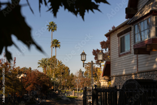 Bakersfield, California, USA - November 24, 2023: Afternoon sun shines on a historic downtown Bakersfield park, street lamps and autumn foliage.