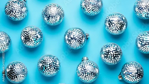 The pattrn of a Shiny silver disco balls over bright background. Creative Christmas pattern. 90s retro party time concept. Xmas holiday background. Top view. Flat lay photo