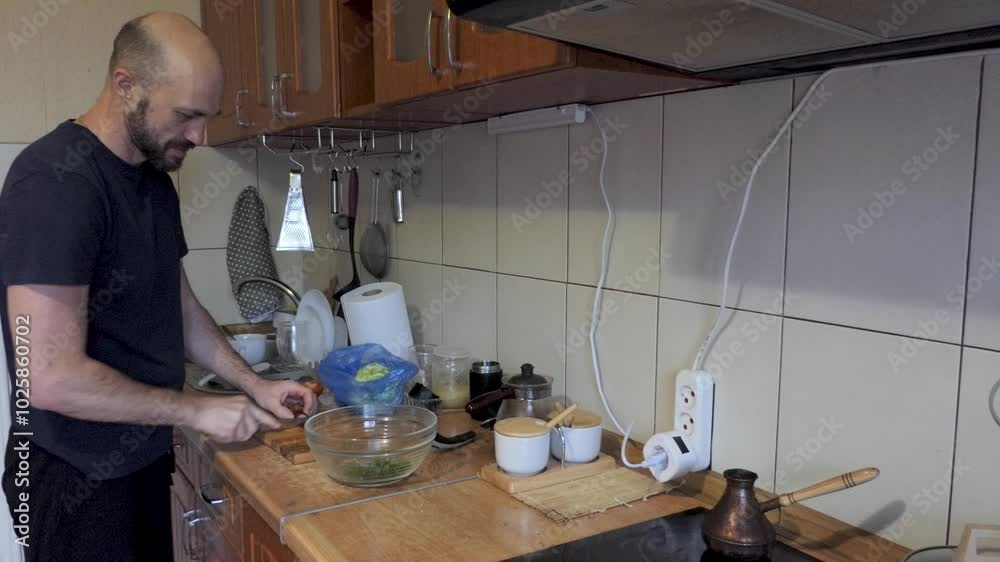 A man fries potatoes in lard in a frying pan on an electric stove A man fries potatoes in lard in a frying pan on an electric stove