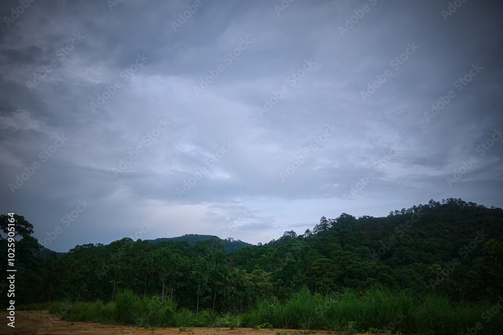 A cloudy sky with a mountain in the background A cloudy sky with a mountain in the background