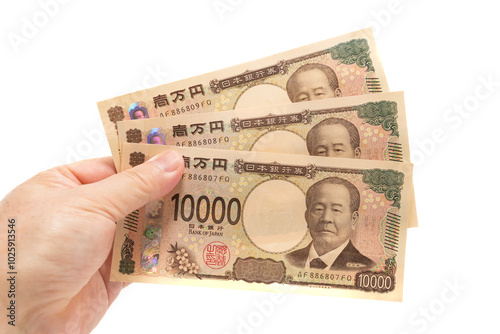 Hand holding new 10,000 yen banknote of Japan isolated on white background
