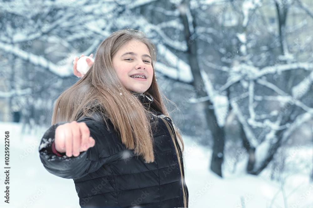 Happy teenager girl throwing snowball in winter park Happy teenager girl throwing snowball in winter park