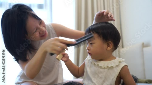 Young Asian mother playing with her daughter at home