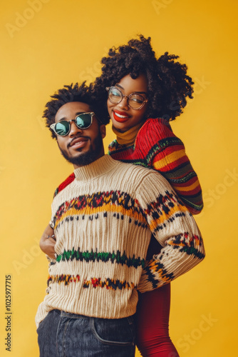 Man and woman in colorful sweaters wearing sunglasses, walking together in a sunny park, surrounded by vibrant autumn leaves.