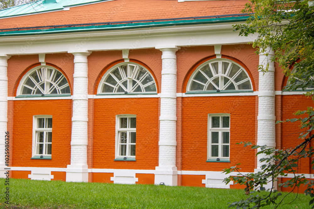 Fototapeta premium Red brick wall with white arched windows