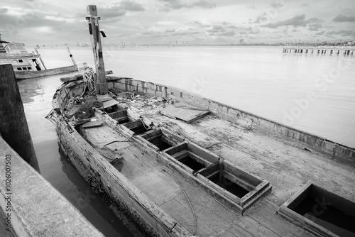 Chonburi, Thailand - May, 26, 2024 : Abandoned Fishing Boat Sinking in Harbor in sunset at Chonburi, Thailand.Black and white photo photo