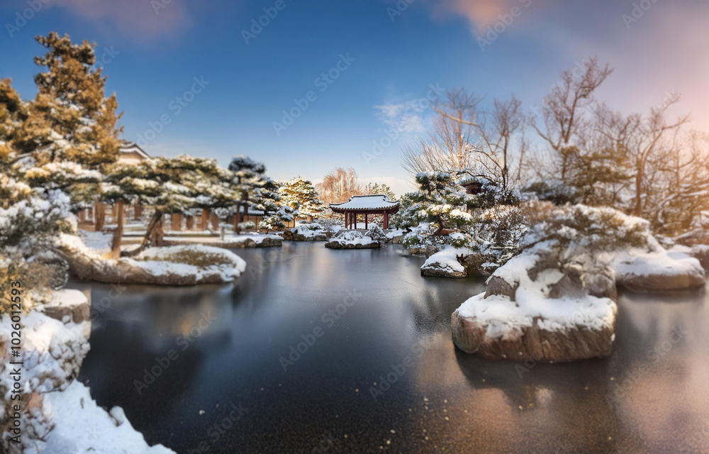 A snow-covered garden with a frozen pond and a wooden gazebo. A snow-covered garden with a frozen pond and a wooden gazebo.