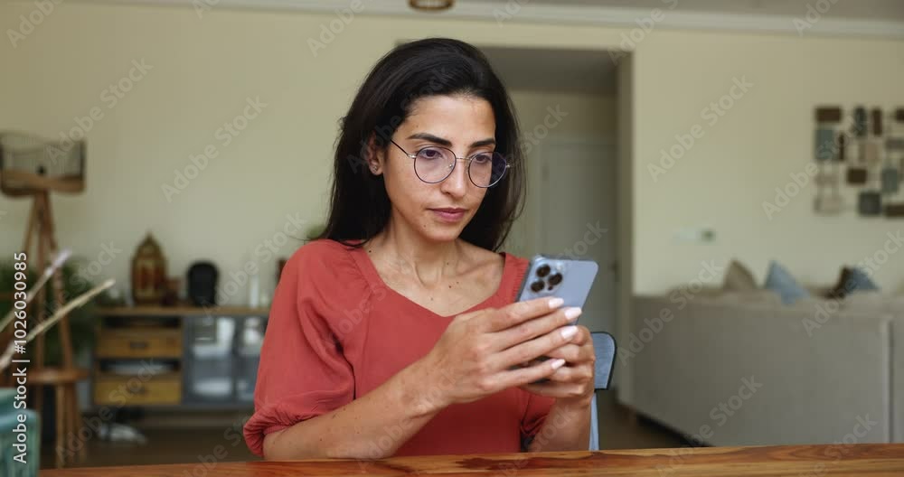 Smiling Latina woman wearing glasses using smartphone, managing personal tasks through her phone. Integration of modern technology in daily life, digital engagement, remote work, online communication Smiling Latina woman wearing glasses using smartphone, managing personal tasks through her phone. Integration of modern technology in daily life, digital engagement, remote work, online communication