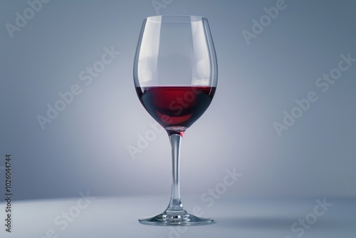 A half-filled glass of red wine on a softly lit surface