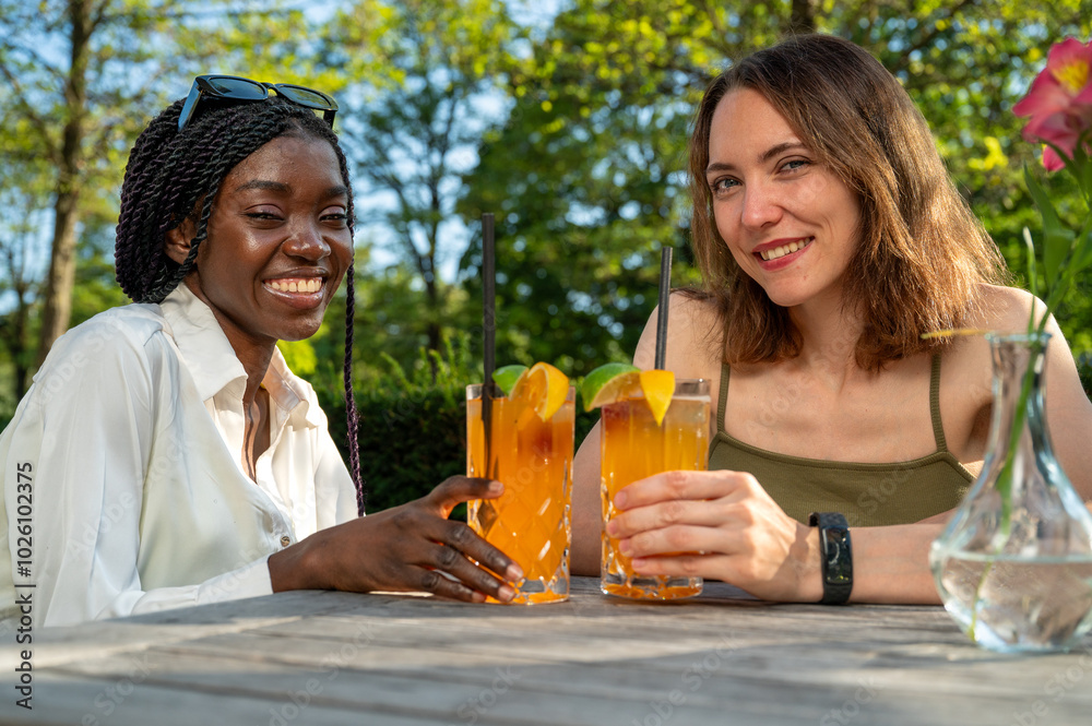 Two young women black caucasian enjoy coktails summer inclusion diversity friendship Two young women black caucasian enjoy coktails summer inclusion diversity friendship