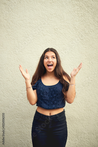 Girl, excited and surprise outdoor by wall for announcement, good news and unexpected event with wow. Female person, shocked and teenager for omg, secret and gossip with disbelief, mind blown and joy photo