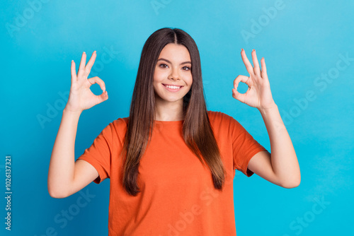 Photo portrait of pretty teen girl okey approve wear trendy orange outfit isolated on blue color background photo