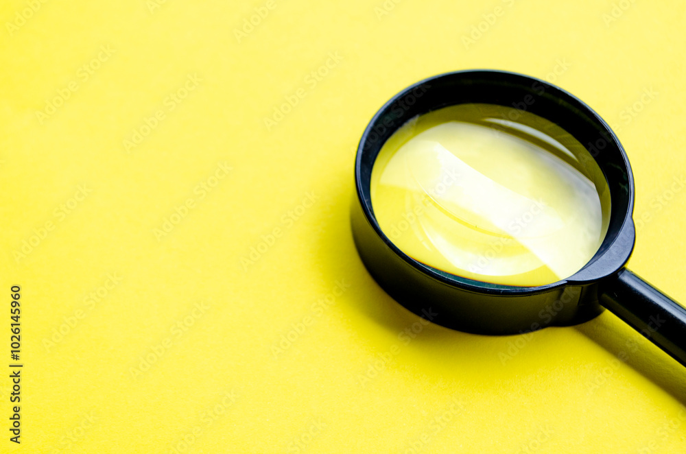 Magnifying glass on yellow cover background with customizable space for text or ideas Magnifying glass on yellow cover background with customizable space for text or ideas