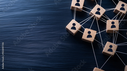 A top-down view of wooden blocks with person icons, placed in a network shape on a smooth surface, with thin strings connecting the blocks, representing social ties and relationshi