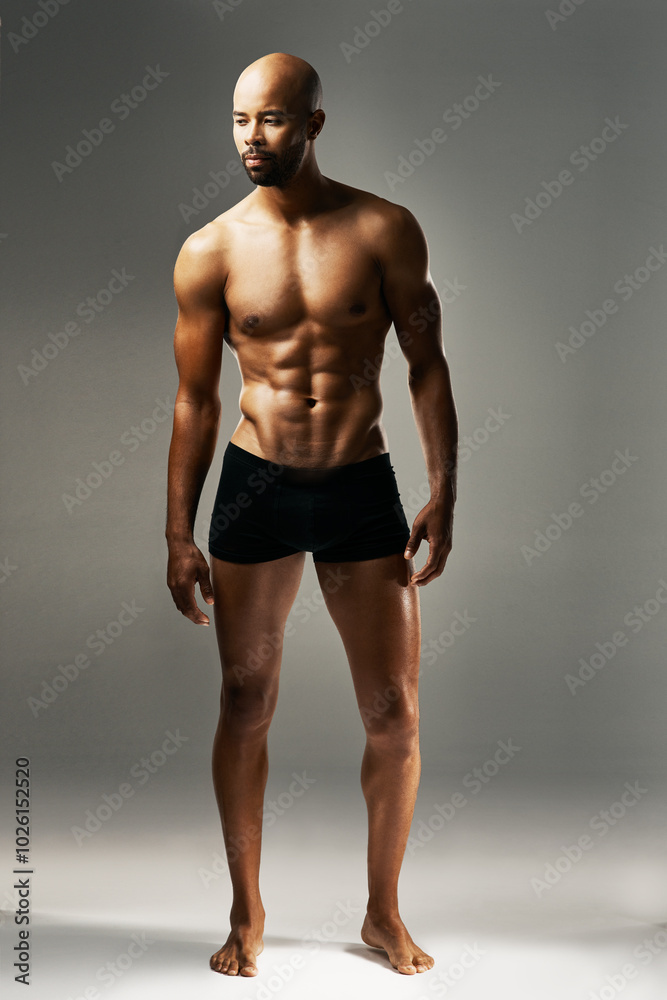 Fitness, body and man in studio with underwear, wellness and gym results for power aesthetic. Confident, proud bodybuilder or strong male model with healthy muscle development on grey background.