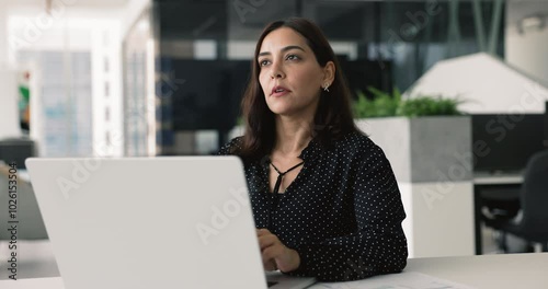 Wallpaper Mural Young 35s woman thinking, pondering, search solution while working on computer. Businesswoman seated at desk, deeply focused on her laptop screen, typing, analyzing data, solve issue, brainstorm ideas Torontodigital.ca