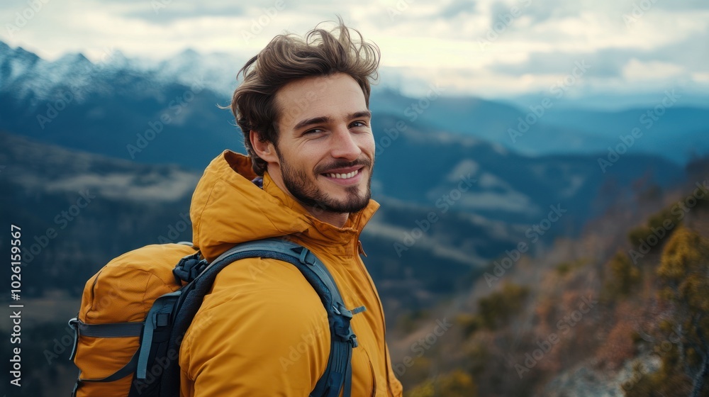 Naklejka premium Handsome man enjoying a scenic mountain hike, taking in the view with a contented smile